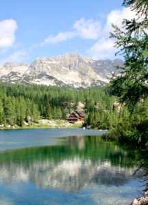 Jasenice lake view with house and mountains Slovenia