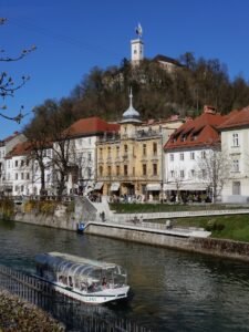 Ljubljancica river with the boat and view on Ljubljana castle on the hill